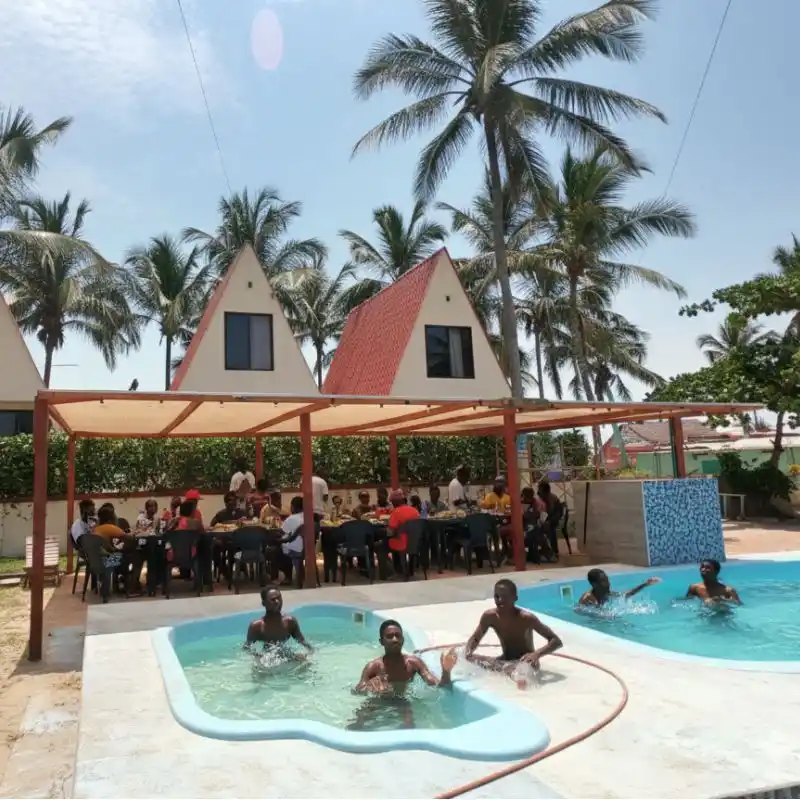 Niños jugando con una pelota en la alberca y chapoteadero frente a las cabañas y la terraza del Club de Playa Mar de Plata, Tuxpan.