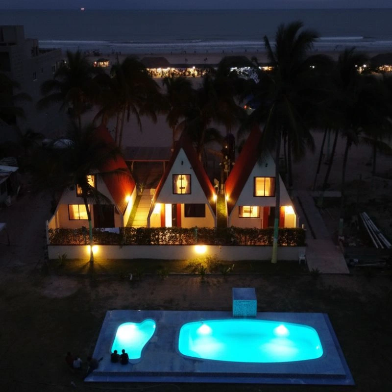 Cabañas tipo alpino iluminadas de noche con alberca privada y vista al mar en el Club de Playa Mar de Plata Tuxpan.
