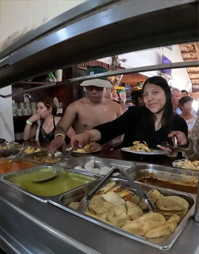 Clientes sirviéndose comida tradicional y antojitos en la barra de desayunos buffet de nuestro restaurante en Tuxpan.