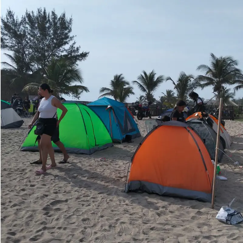 Turistas en tiendas de campaña disfrutando de la zona de camping segura frente al mar en el Club de Playa Mar de Plata Tuxpan.