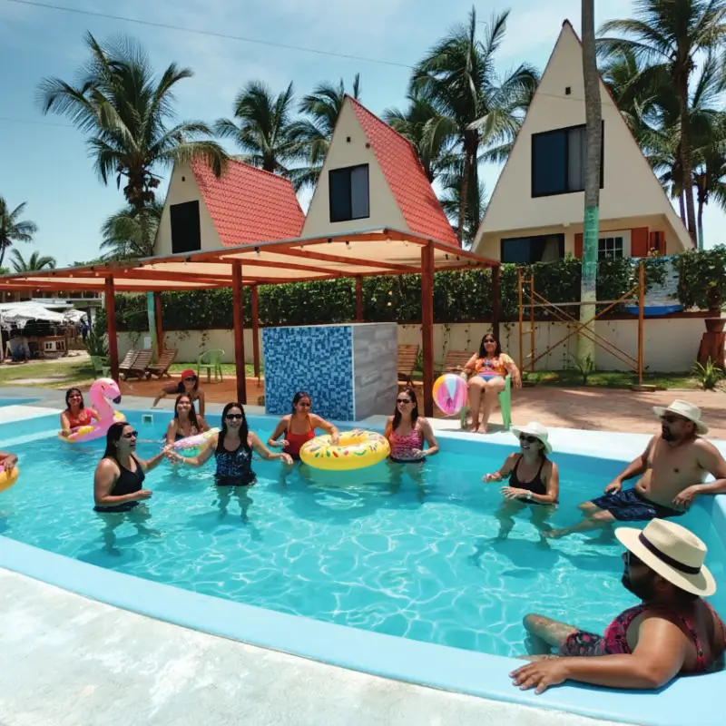 Familia y amigos disfrutando en la alberca frente a las exclusivas cabañas familiares en el club de playa Mar de Plata Tuxpan.