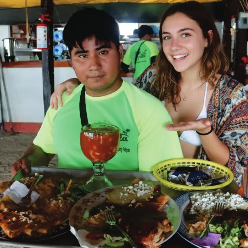 Clienta sonriente recibiendo un gran coctel de mariscos y platillos con sazón tuxpeño en el restaurante Mar de Plata.